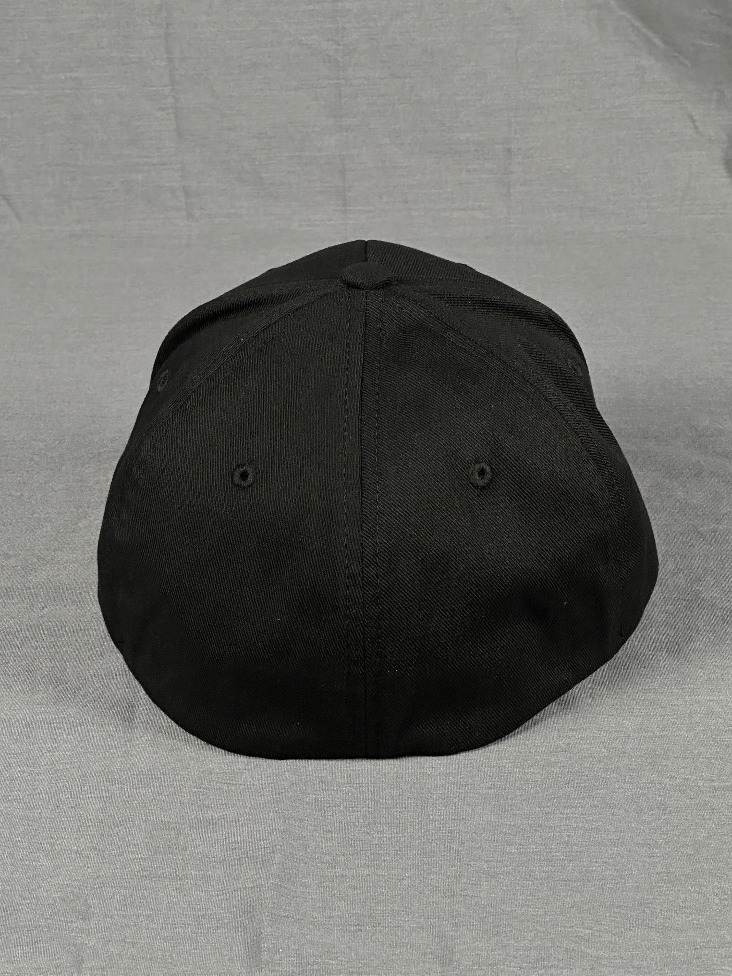 Back view of black Flexfit fitted hat showing closed stretch band