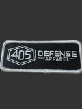 405 Defense Apparel embroidered morale patch featuring the hex logo and Defense Apparel text in white stitching on a black background with hook backing.
