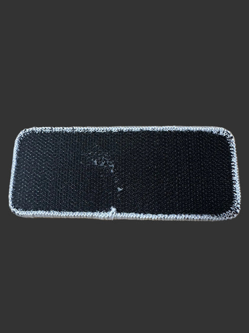 Rear view of 405 Defense Apparel morale patch showing durable hook backing for attachment to tactical gear, range bags, backpacks, and jackets.