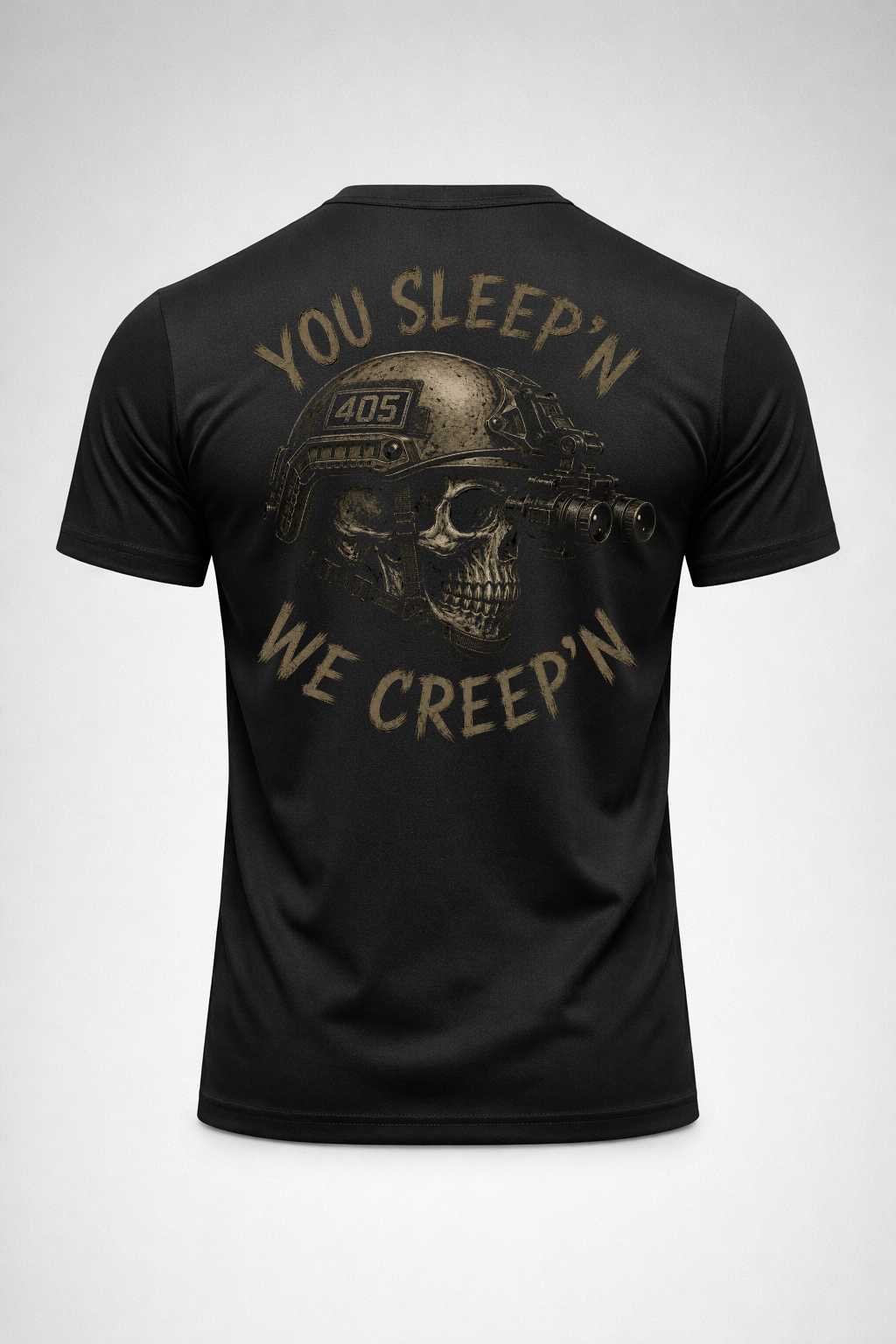 Back view of a black tactical graphic t-shirt featuring a skull wearing a helmet with night vision and the phrase “You Sleep’n We Creep’n” in distressed tan print.